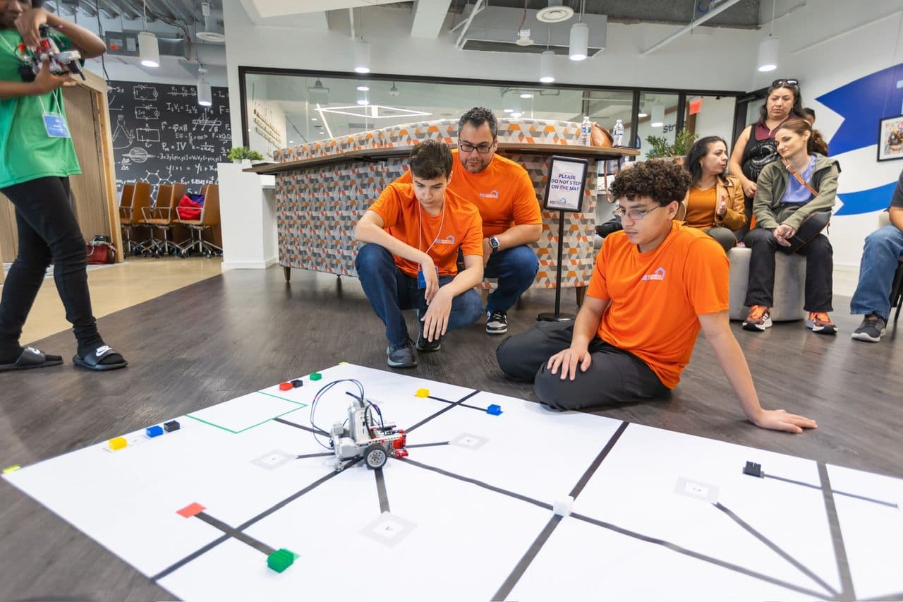Eyes on the mat. The Cogsmiths watch their robot run the course during the nationals in Virginia.