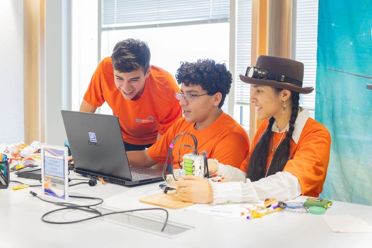 Programming between rounds. The team refined their robot's sensor logic and navigation code on-site.