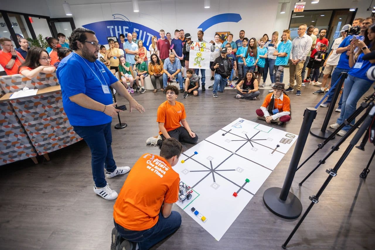 The competition floor at K12 headquarters. Teams ran their robots on a gridded mat while judges scored and the crowd watched.